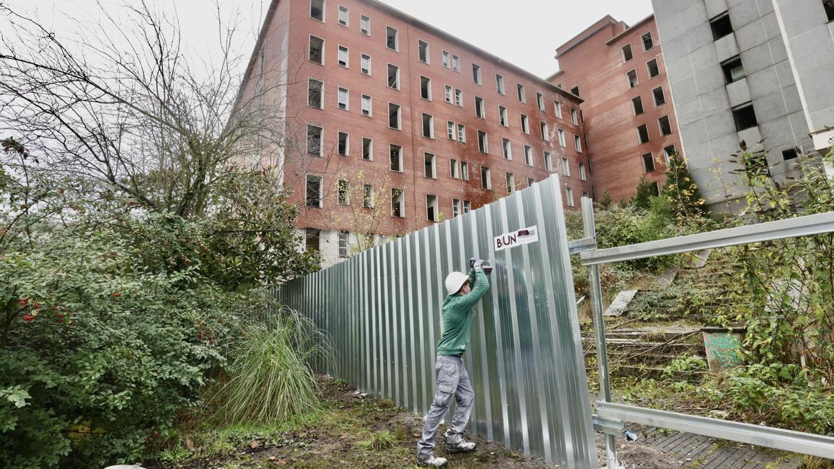 Un operario colocando las vallas alrededor de la Residencia.