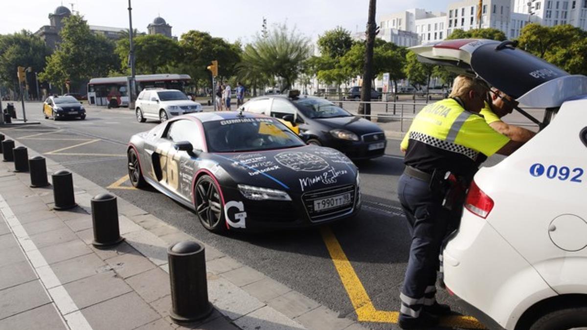 Una pareja de policías comprueban los papeles de uno de los coches de lujo participantes en la 'Gumball 3000', el pasado martes.