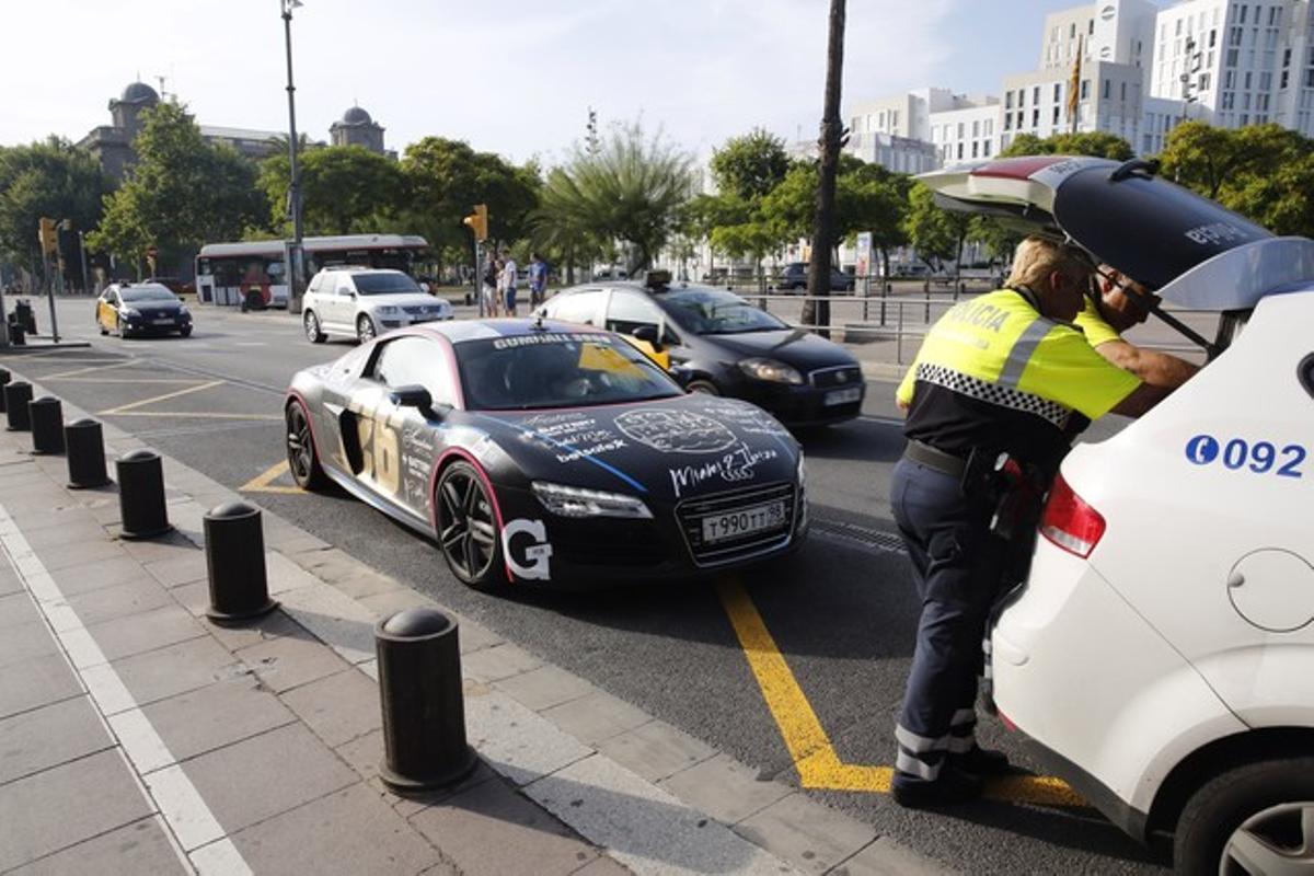 Una parella de policies comproven els papers d’un dels cotxes de luxe participants en la {’Gumball} 3000’, dimarts passat.