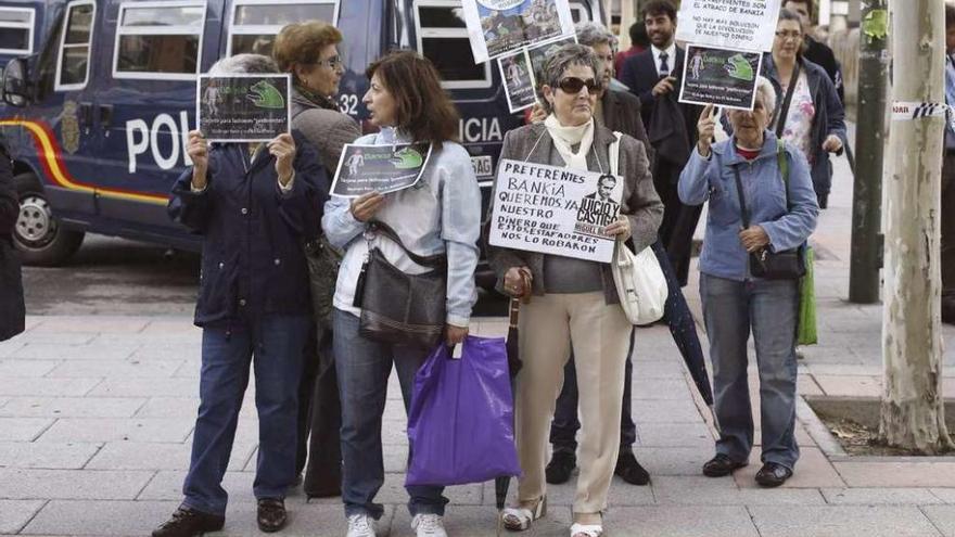 Protesta de afectados por las preferentes de Caja Madrid y Bankia, durante la comparecencia anteayer de Rodrigo Rato en el juzgado. // Efe