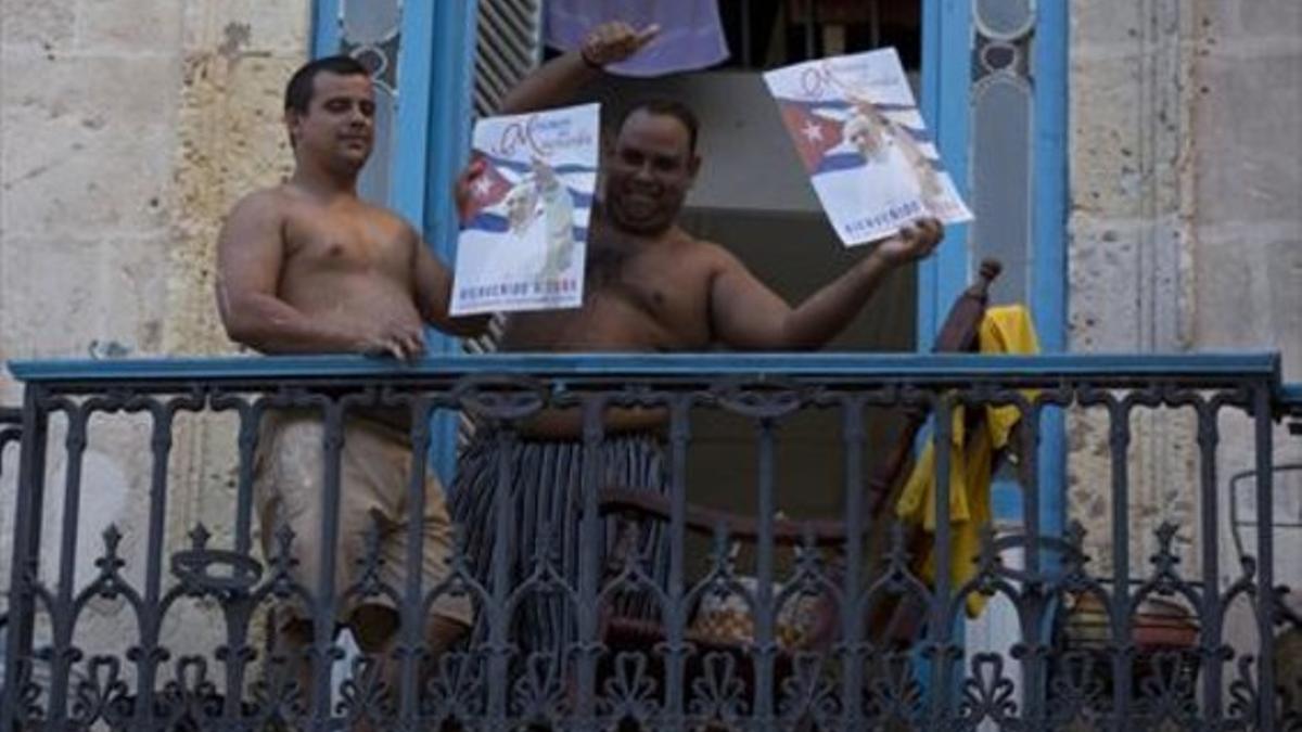 Dos ciudadanos cubanos dan la bienvenida a Francisco, ayer enLa Habana.