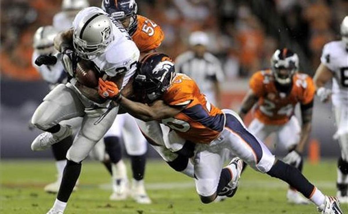 Els jugadors del Denver Broncos Jason Hunter i Brian Dawkins, durant un partit contra els Raiders d’Oakland a Denver, Colorado.