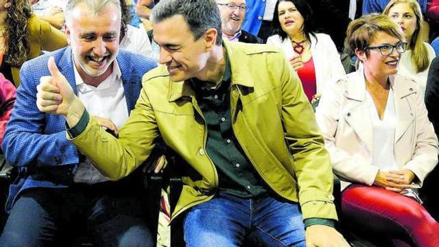 Pedro Sánchez guiña un ojo durante un acto del PSOE con el exdiputado Juan Bernardo Fuentes Curbelo, el ‘tito Berni’, asomando tras su hombro.