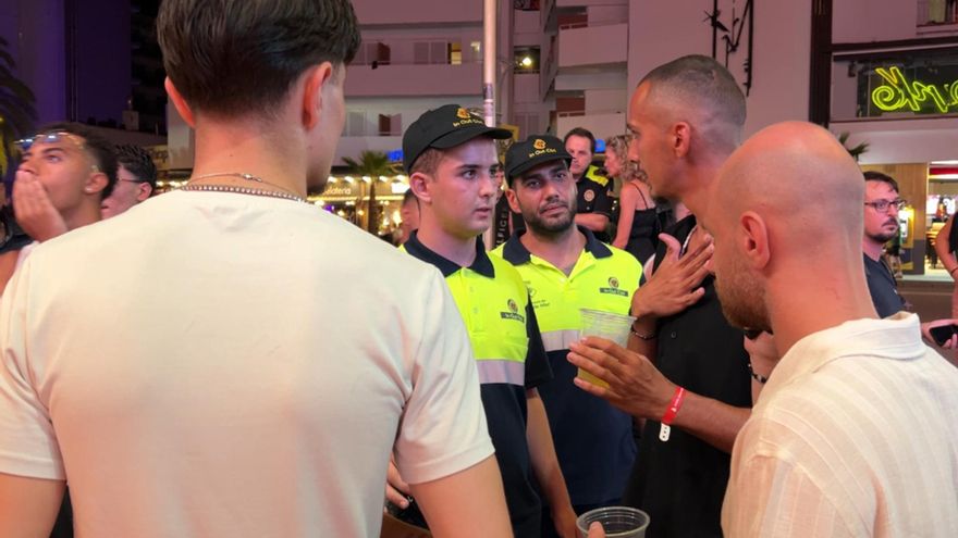 Dos agents cívics, avisant a un grup de nois que no es pot consumir alcohol a la via pública