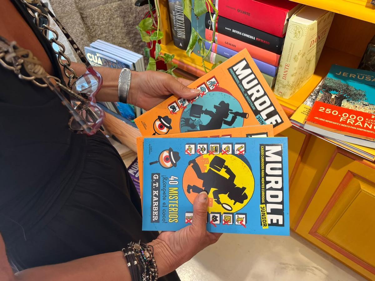 María, trabajadora en Cronopios, con varios ejemplares de Murdle entre las manos.