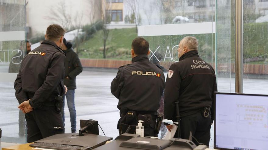 Dos policías nacionales junto a un vigilante de seguridad privada, esta semana en la Ciudad de la Justicia.   | // ALBA VILLAR