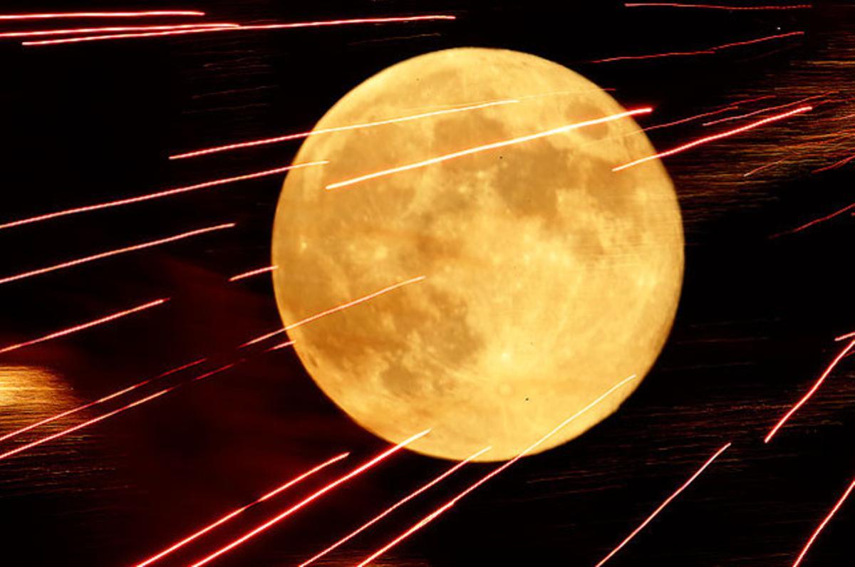 Focs artificials il·luminen el cel amb la lluna plena al fons, durant la celebració del 4 de Juliol, a Kansas (EUA).