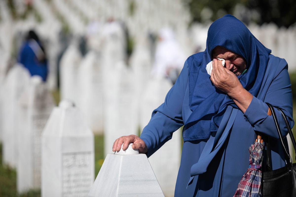 Una mujer bosnia musulmana visita las lápidas durante la ceremonia de entierro de cincuenta víctimas musulmanas bosnias recién identificadas, en el Centro Conmemorativo y Cementerio de Potocari, en Srebrenica (Bosnia y Herzegovina), el 11 de julio de 2022. 