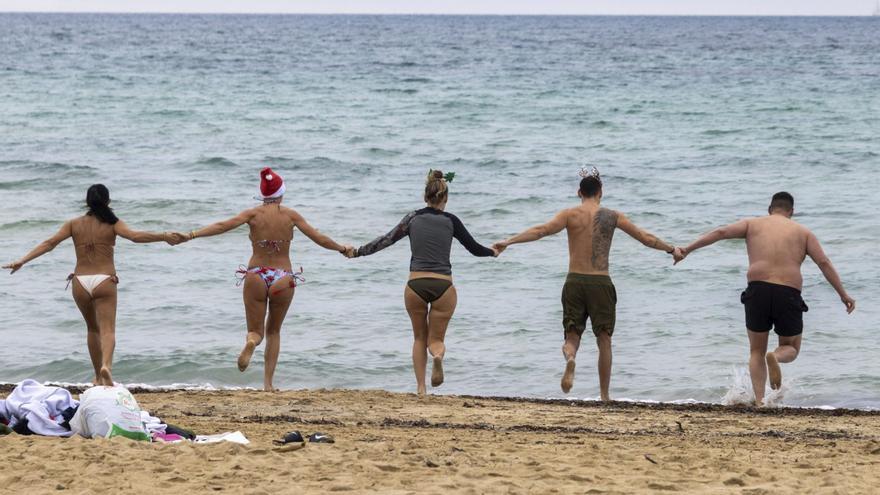 Eine Freundesgruppe beim Neujahrsbad am Strand von Ciutat Jardí.