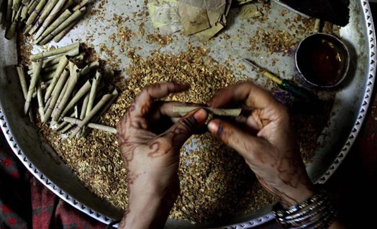 Una dona índia fa un ’bidi’ --tabac ratllat enrotllat a mà-- a Prantij, a prop de Himmatnagar, a uns 60 quilòmetres al nord d’Ahmadabad (Índia).