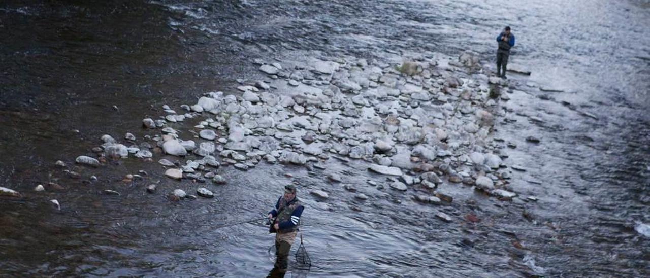 Dos pescadores, durante los primeros días de la temporada, en el río Nalón.