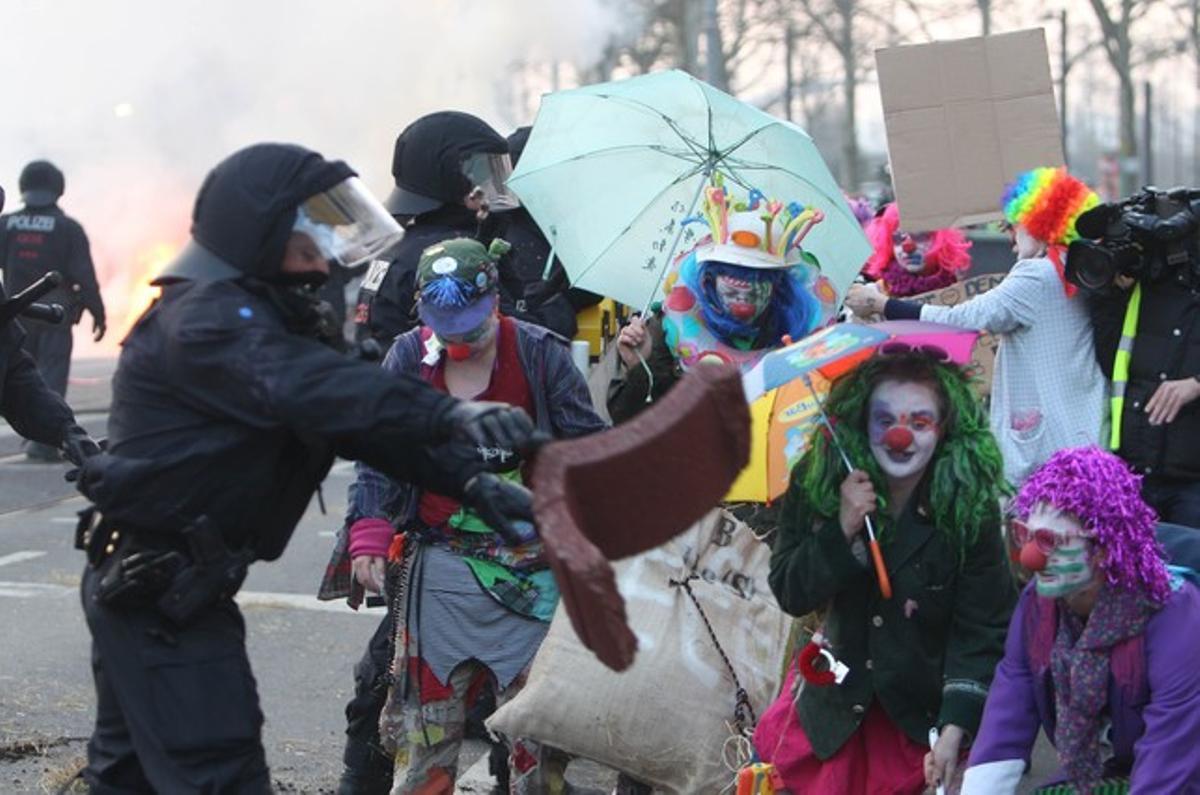 Manifestants vestits de pallassos s’encaren a diversos agents.