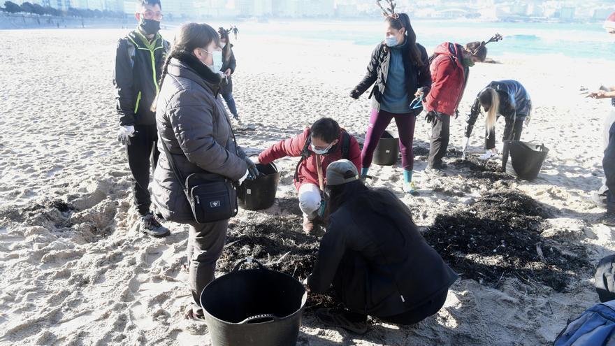 Socios y socias de Down Coruña limpian la playa del Orzán