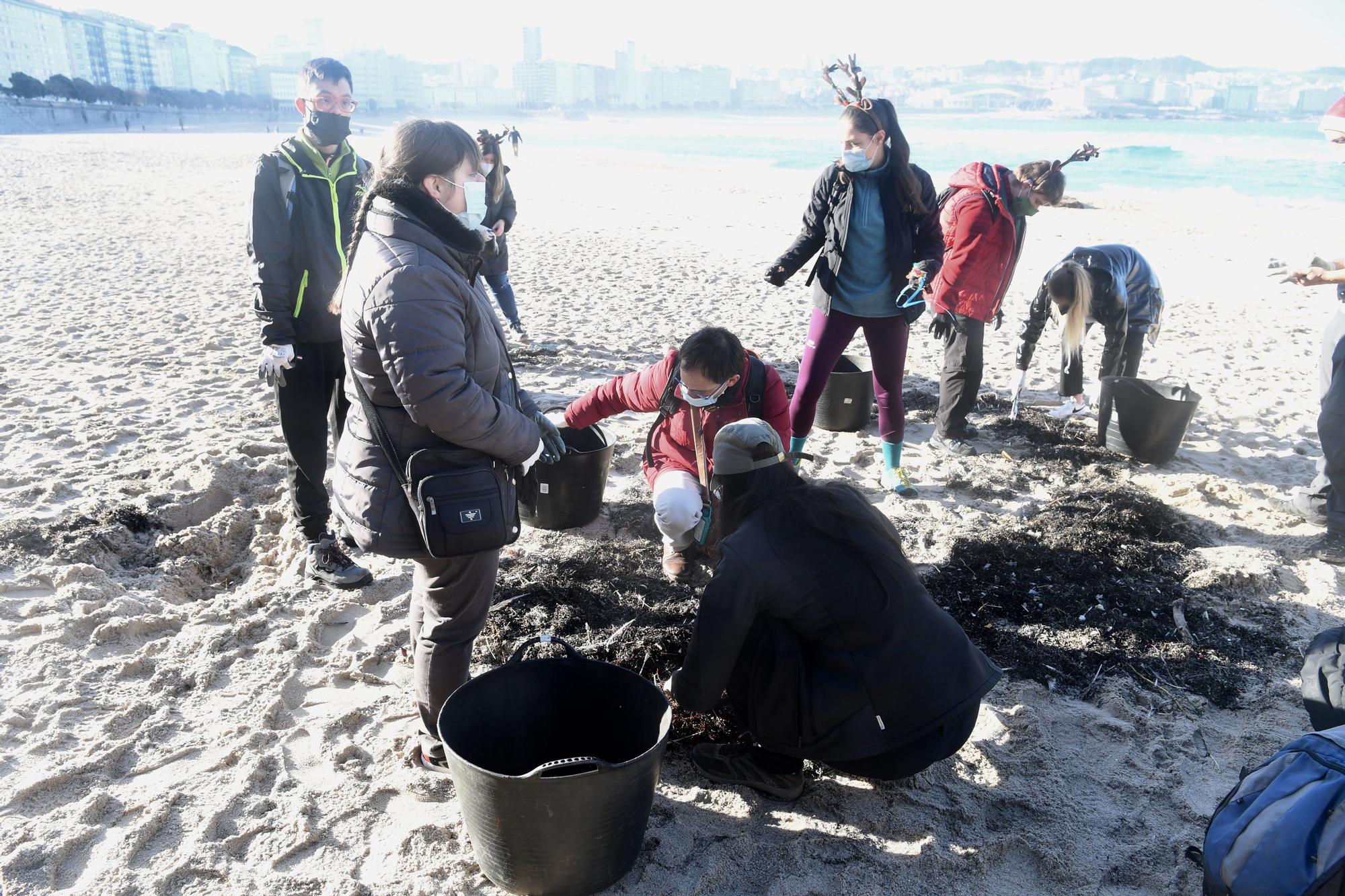 Socios y socias de Down Coruña limpian la playa del Orzán