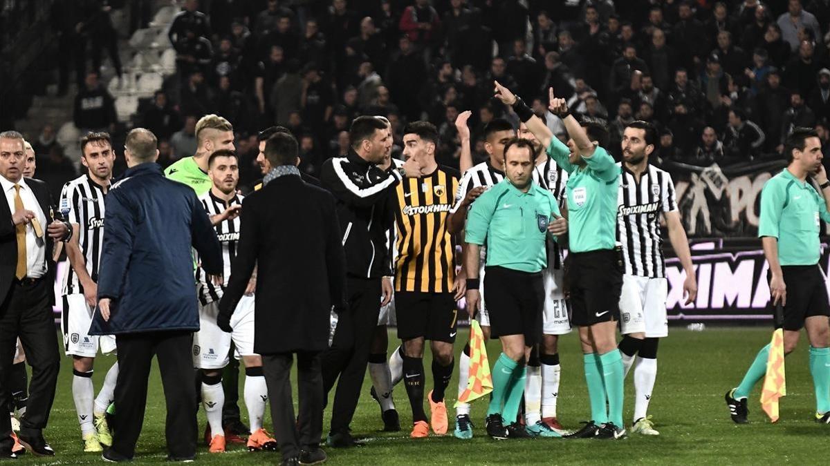 Árbitros y jugadores, durante los incidentes en el tramo final del partido en campo del PAOK.