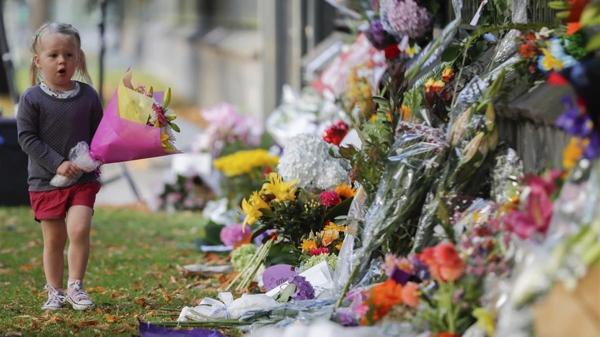 Una niña pone flores en el memorial de recuerdo del atentado en Christchurch, el pasado mes de marzo.