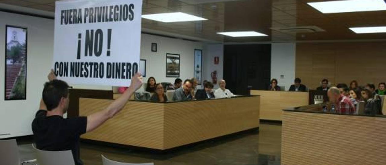 El vecino expulsado, con una pancarta en un pleno.