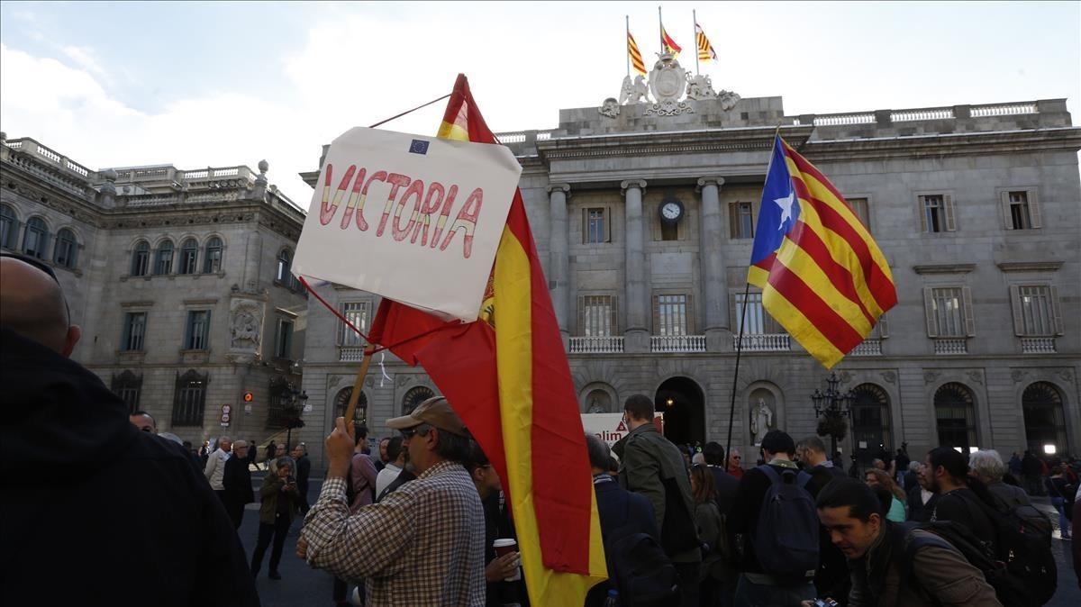 Un manifestante con una estelada y otro con una bandera española en la plaza de Sant Jaume.