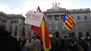 Un manifestante con una estelada y otro con una bandera española en la plaza de Sant Jaume.