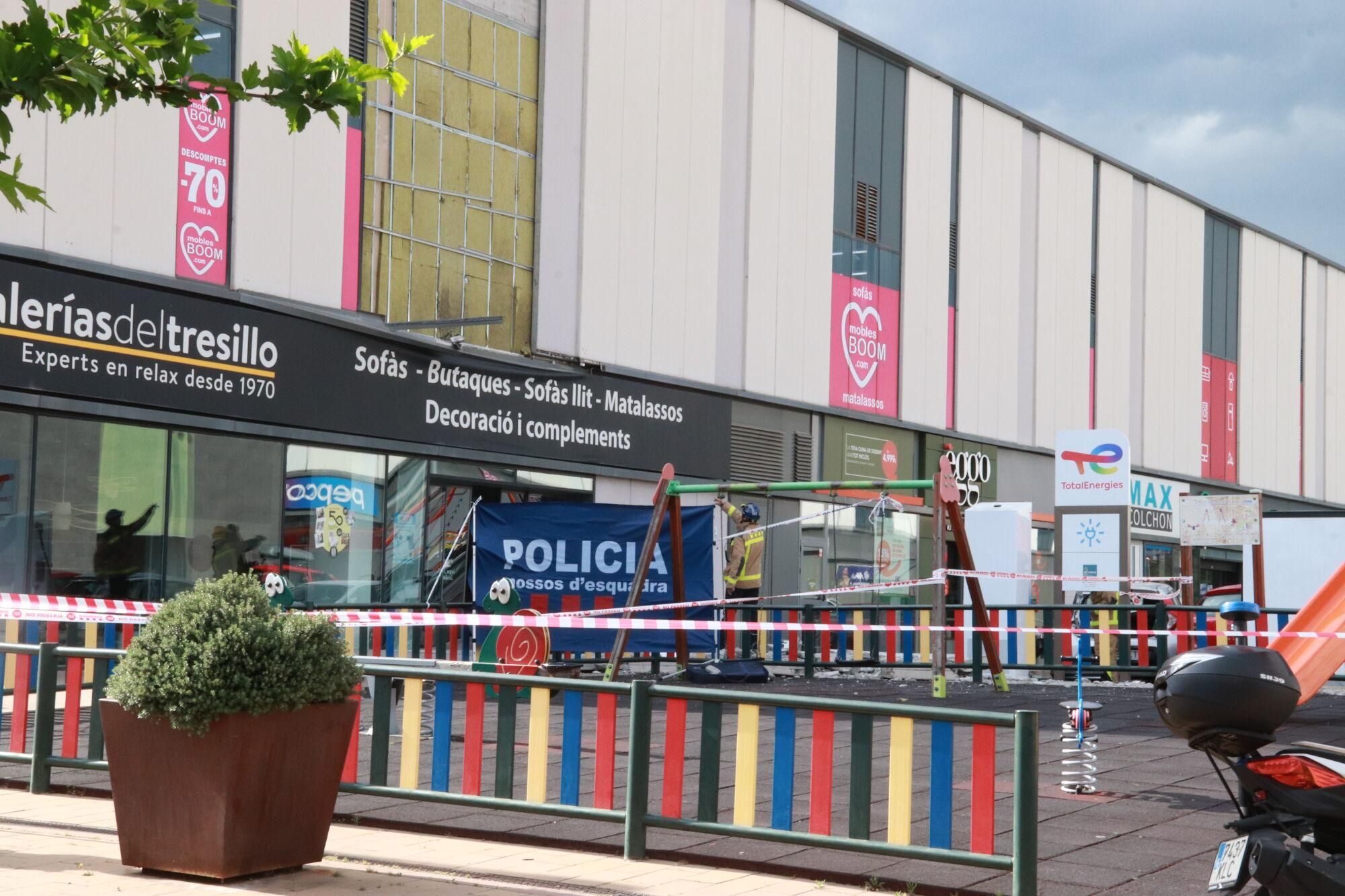 Zona acordonada davant d'un establiment del centre comercial Via Sabadell del qual s'ha desprès una part de la façana, que ha atrapat una persona