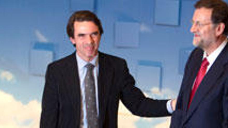 José María Aznar, aclamado como gran protagonista, junto a Mariano Rajoy, en la convención de Sevilla.