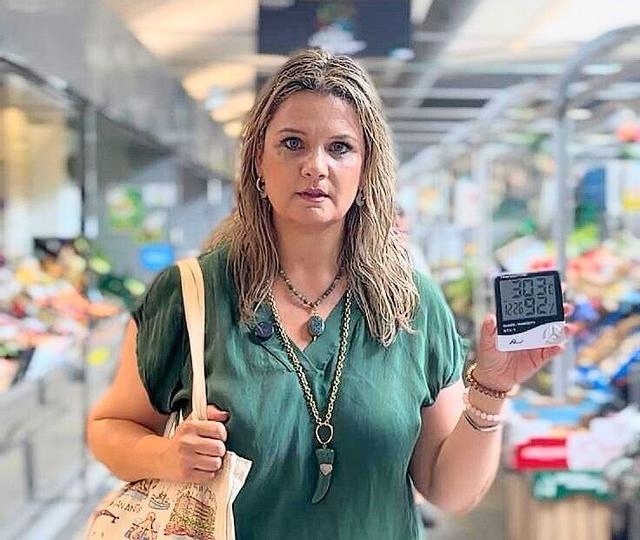 Carmen No, concejala PP Coruña, muestra la temperatura en el interior del mercado de la plaza de Lugo.