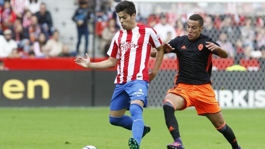 Jorge Meré y Rodrigo en el último duelo entre Sporting y Valencia disputado en El Molinón