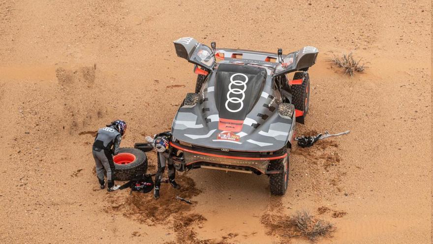 Carlos Sainz y su copiloto Lucas Cruz tratan de solucionar uno de los dos pinchazos en una etapa marcada por la lluvia. | ASO