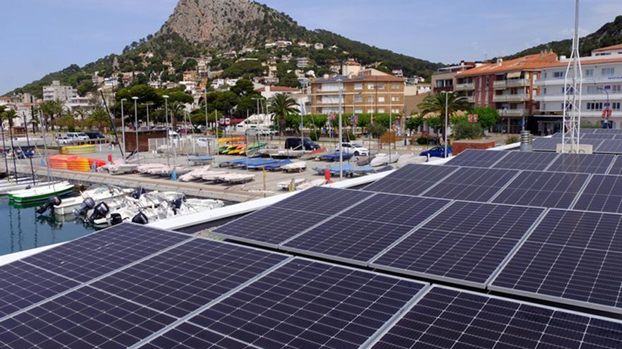 El sostre d'un edifici del port nàutic de l'Estartit amb plaques solars amb la muntanya del Rocamaura i la població de l'Estartit de fons