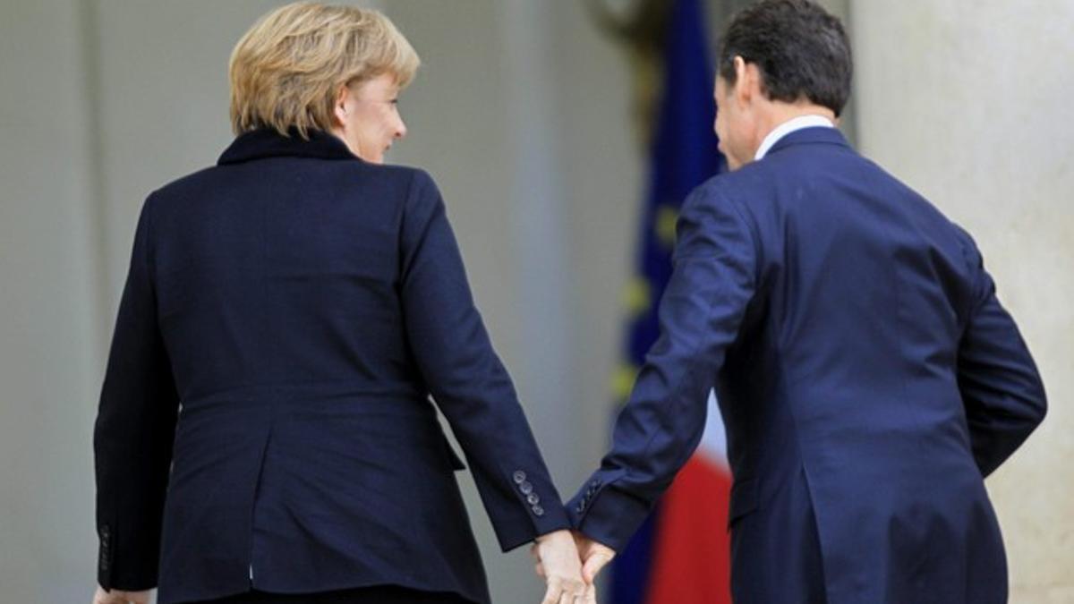 Sarkozy y Merkel se saludan en la entrada del palacio del Eliseo, en París.