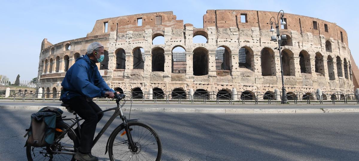 Un ciclista frente al Coliseo de Roma.