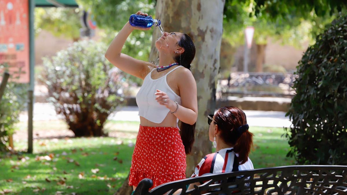 Una mujer se refresca bebiendo agua de una botella en Córdoba.