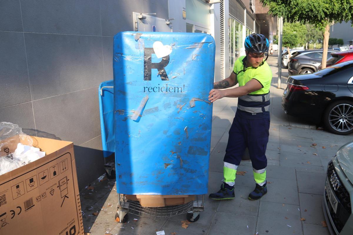 Un operari recull les escombraries d'un comerç de Platja d'Aro.