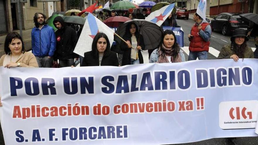 Las trabajadoras del SAF de Forcarei, ayer, con su pancarta en la manifestación del Primero de Mayo de la CIG en A Estrada.//Bernabé/Javier Lalín