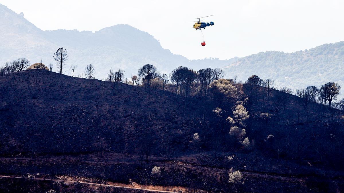 Un helicóptero participa en la extinción del incendio de Sierra Bermeja.