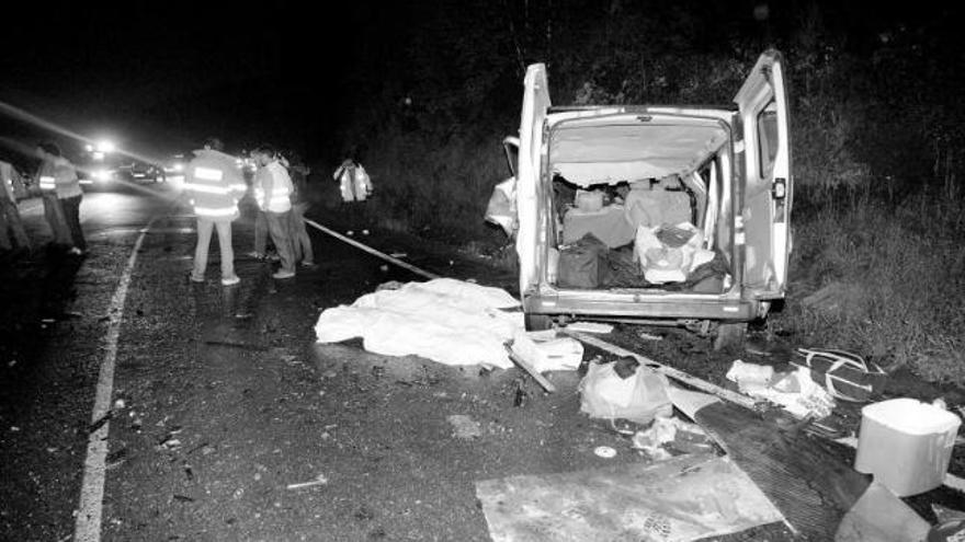 La furgoneta siniestrada, con los tres cadáveres tapados con mantas sobre el asfalto.