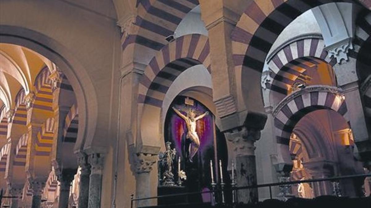 Interior de la mezquita-catedral de Córdoba, con un altar presidido por un gran crucifijo y una virgen de plata.