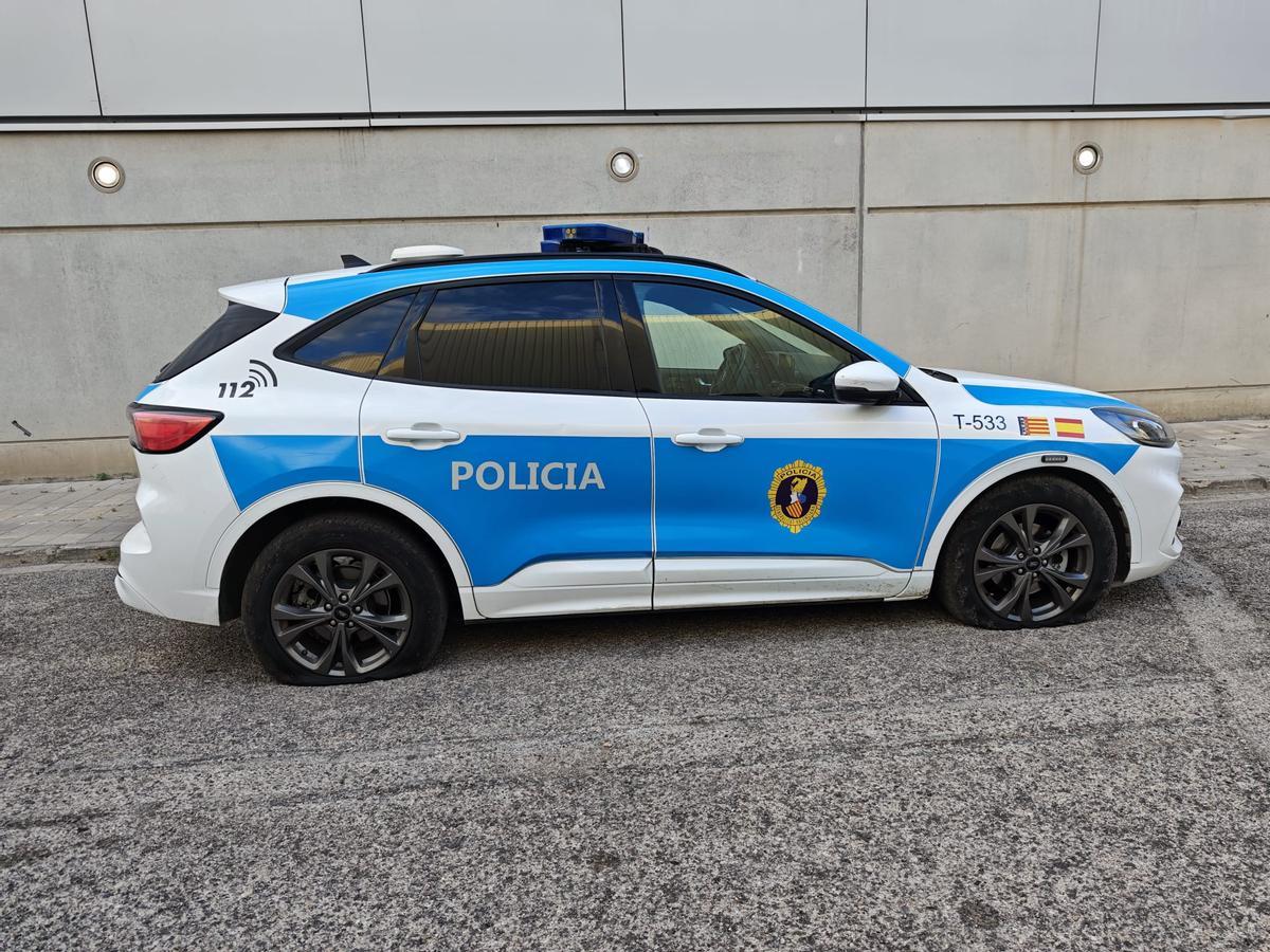 El coche patrulla de la Policía autonómica de València vandalizado, con las ruedas pinchadas.