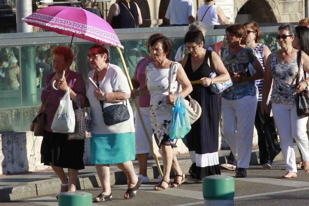 Cientos de miles de seguidores acompañan a la procesión por el centro de Vigo en medio de un asfixiante calor.