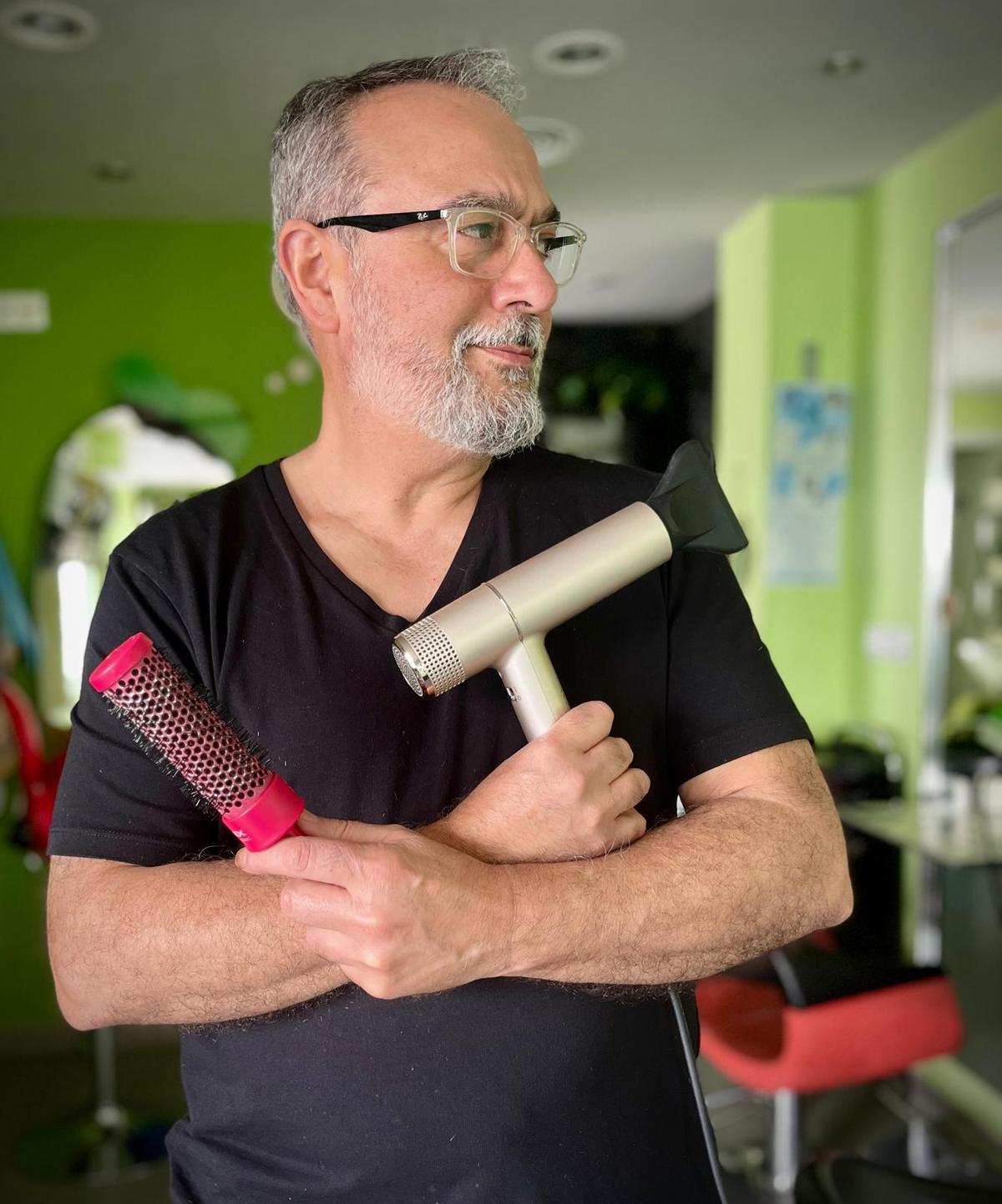 Santi, entre el secador y el cepillo, dos de las herramientas que han marcado casi cuatro décadas de oficio.