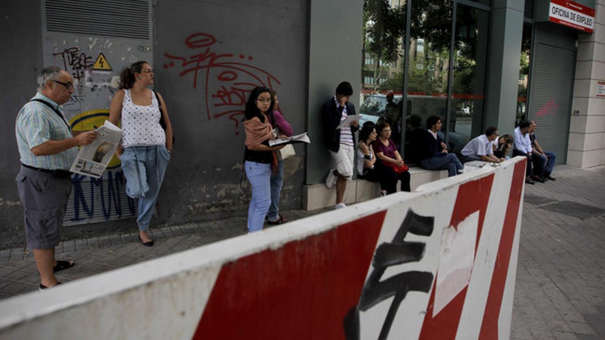 Varias personas esperan a que abra una oficina de empleo, el jueves, en Madrid.