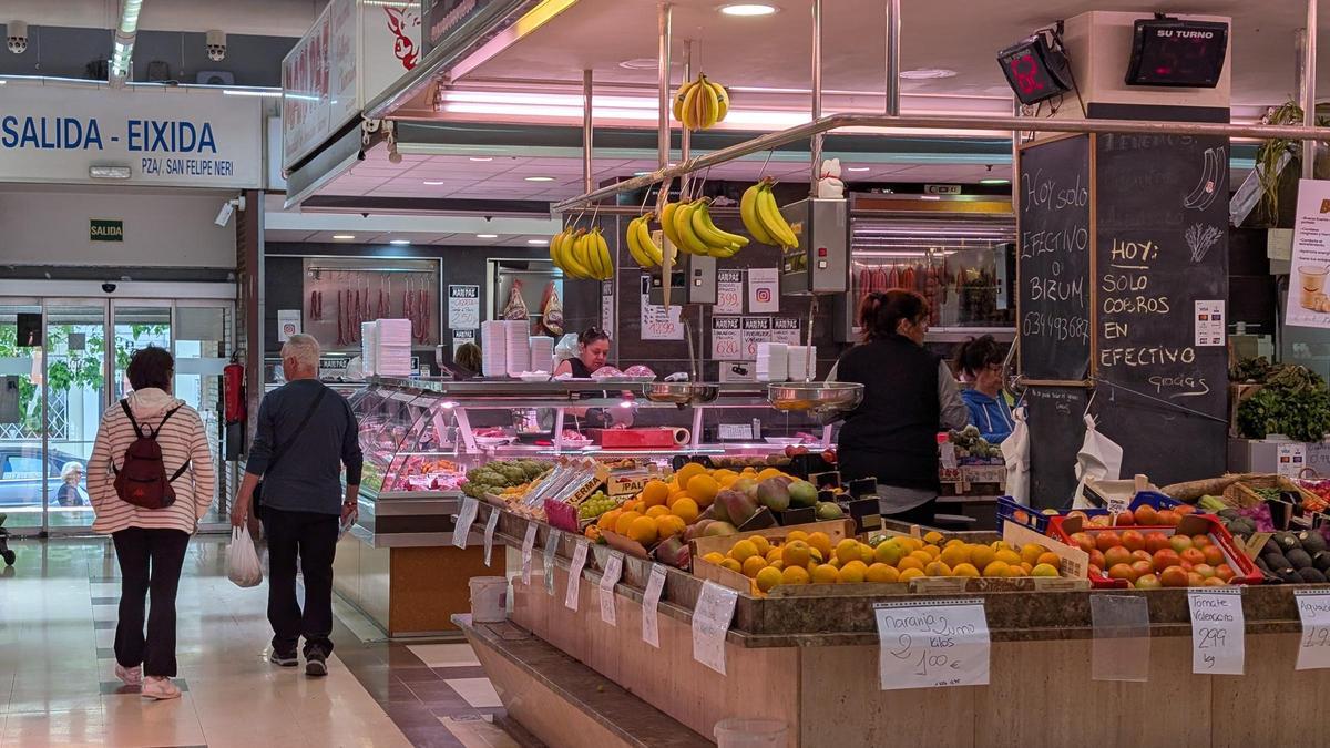 Varias personas comprando en el mercado de Algirós.