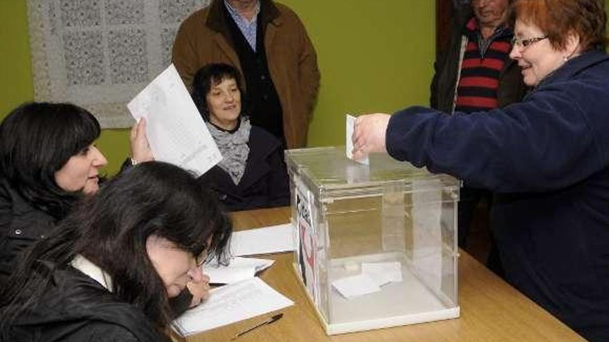 Una vecina depositando su voto, ayer, en Lamela.  // Bernabé/Javier Lalín