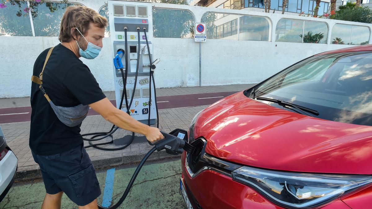 Un conductor de un coche eléctrico en un punto de recarga.