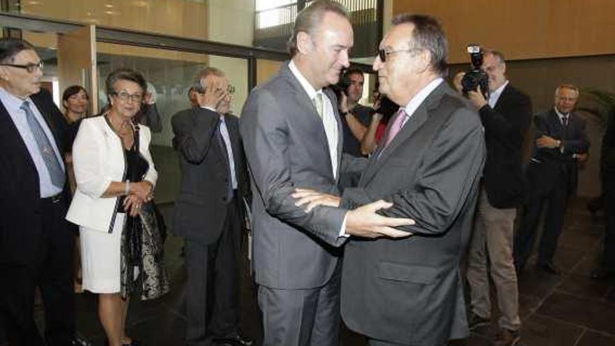 El presidente de la Generalitat se abraza a Carlos Fabra, durante un acto en la Cámara de Comercio de Castellón.
