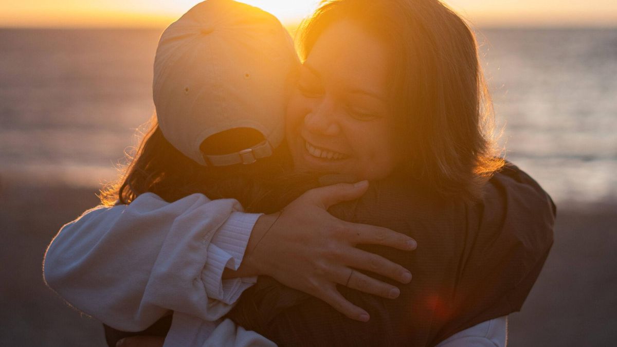 Dos jóvenes se abrazan tras una sesión de meditación.