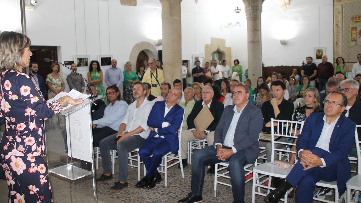 María Curiel habla ante un auditorio lleno en el Palacio de Carvajal.