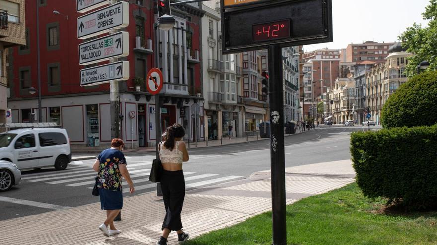 Dos ciudadanas pasean mientras el termómetro marca 42 grados de temperatura.