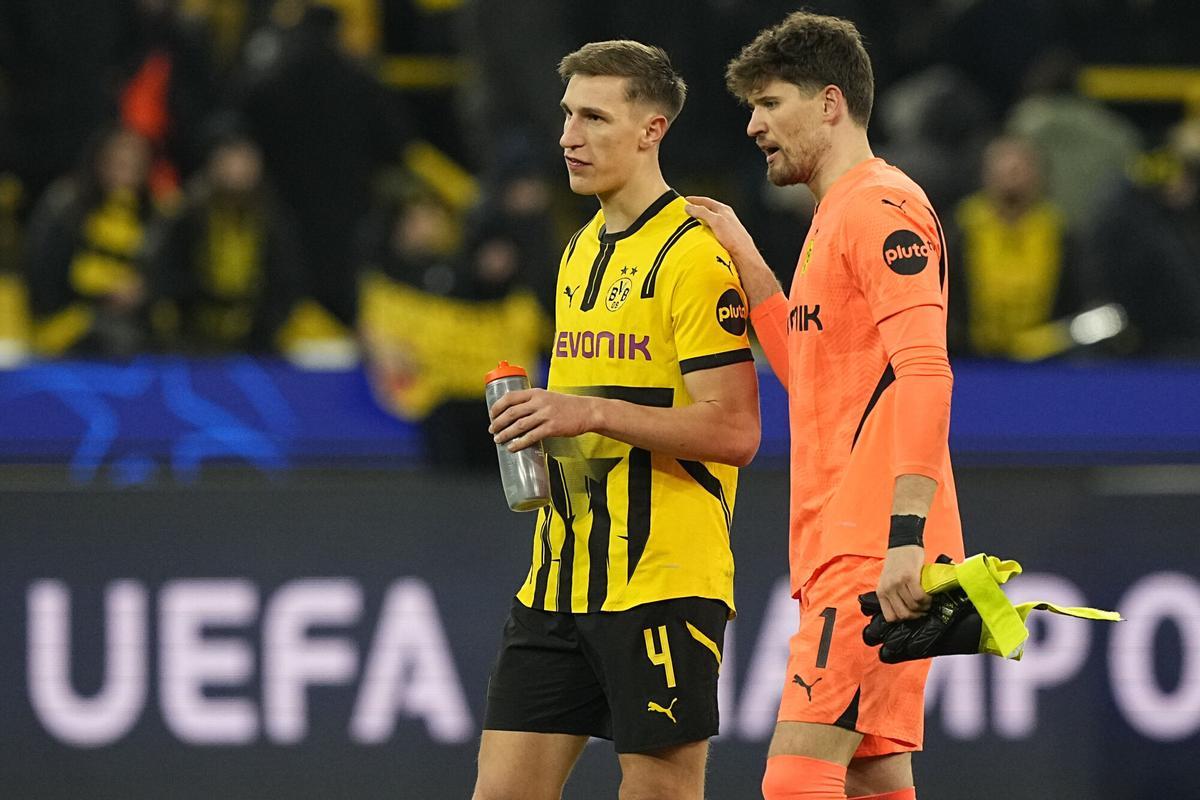 Dortmund's goalkeeper Gregor Kobel and Dortmund's Nico Schlotterbeck walk to Borussia fans after the Champions League playoff second leg soccer match between Borussia Dortmund and Sporting CP at the Signa-Iduna Park in Dortmund, Germany, Wednesday, Feb. 19, 2025. (AP Photo/Martin Meissner)