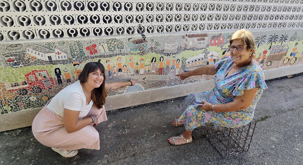 Carmelita y su nieta y ayudante Antía, con el último mosaico que han creado, la parranda de San Roque.